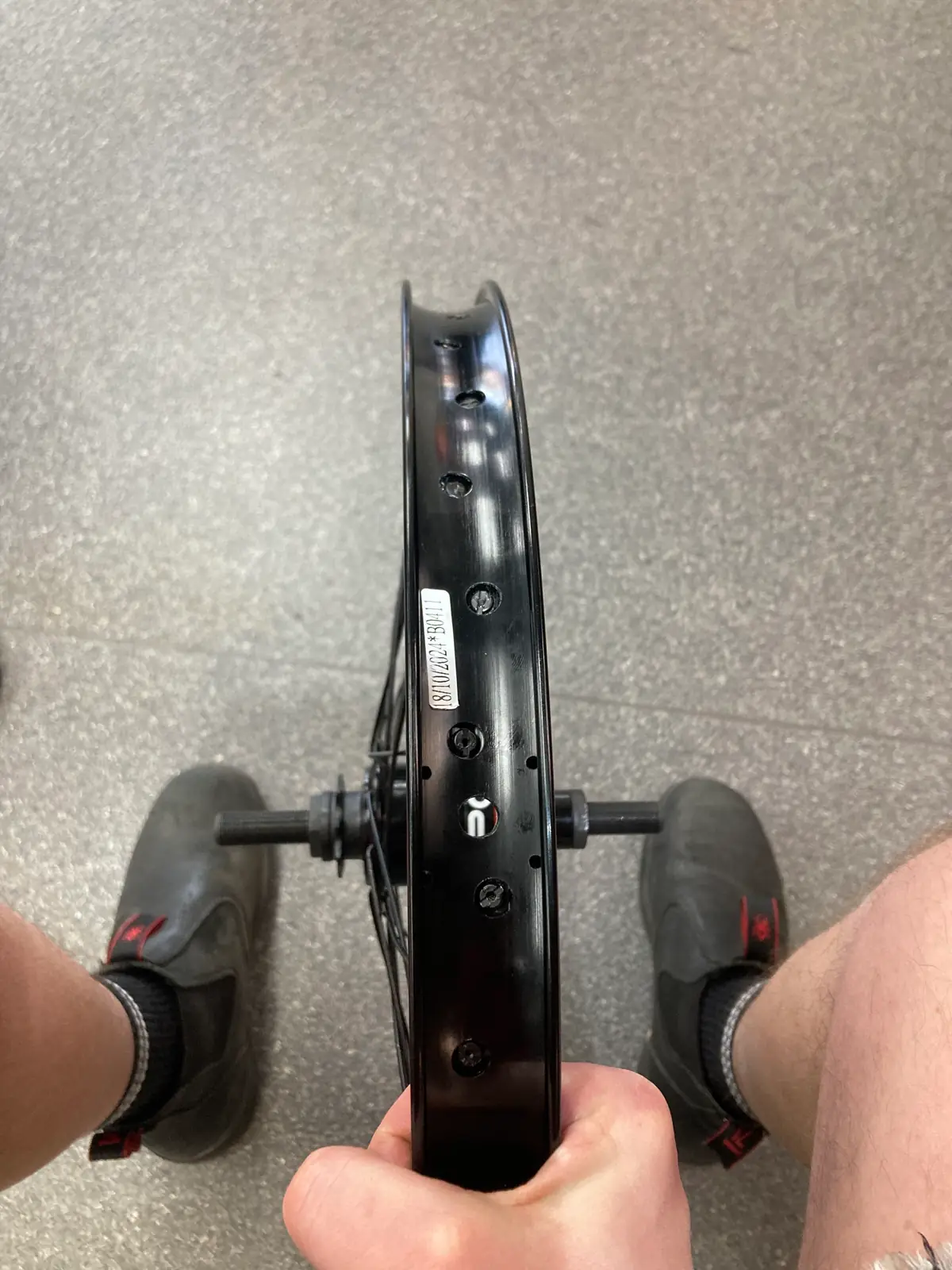 A bare BMX rim being checked before lacing