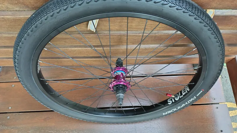 A finished 24-inch BMX cruiser rear wheel with a pink hub