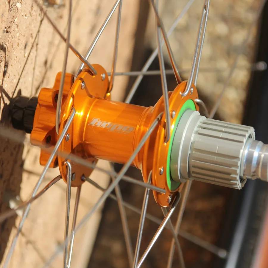 Orange Hope rear hub laced into a gravel wheel, built by New South Wheels